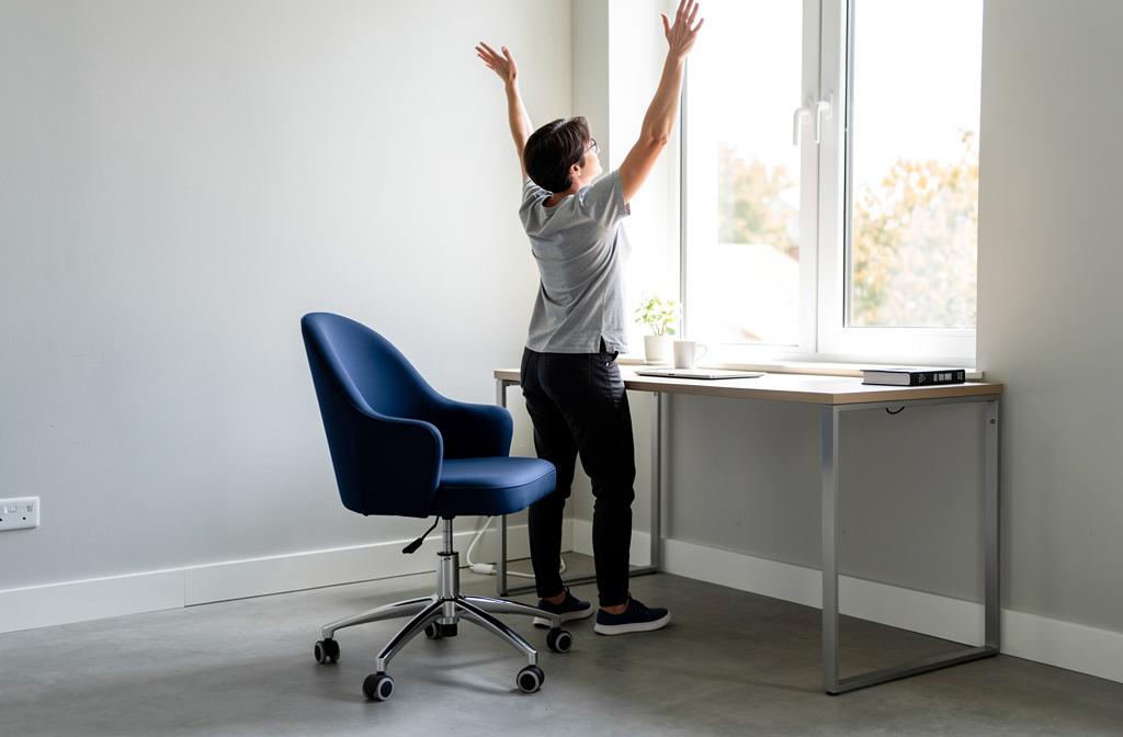 Granatowy obrotowy fotel biurowy przy biurku podczas przerwy w pracy