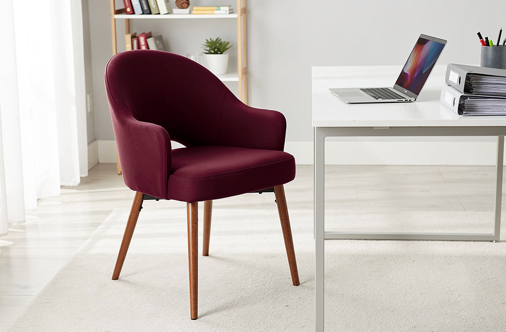 Bordowy obrotowy fotel biurowy przy biurku w zorganizowanym domowym biurze