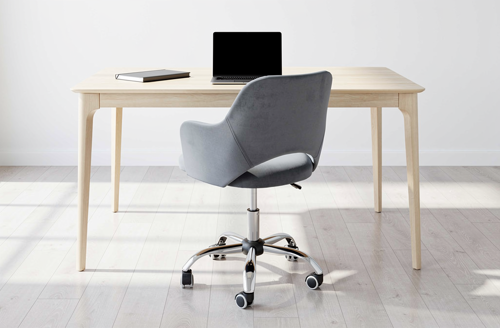 Ergonomiczne szare krzesło biurowe na kółkach przy biurku w jasnym biurze.